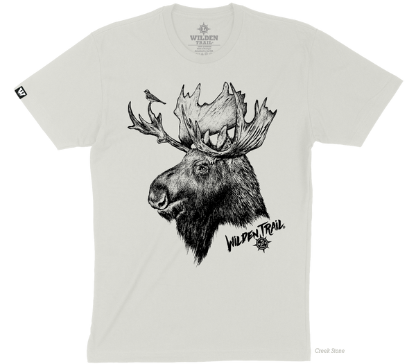 A light tan colored tshirt with a moose sketched image on the front of the tshirt. There is a small bird on the Moose's antler. The words "Wilden Trail" and the logo appear on the bottom right hand side of the image.