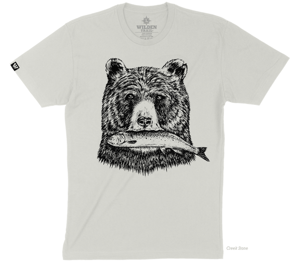 A light tan t-shirt with a black printed design of a grizzly bear's head holding a fish in its mouth.